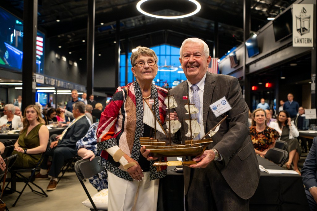 2025 Citizen of the Year Bill Cummings with a guest, holding the Chamber award at the Medford Chamber banquet