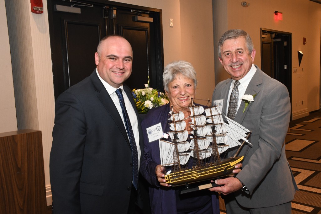 2023 Citizen of the Year recipient with presenters, holding a model sailing ship award.